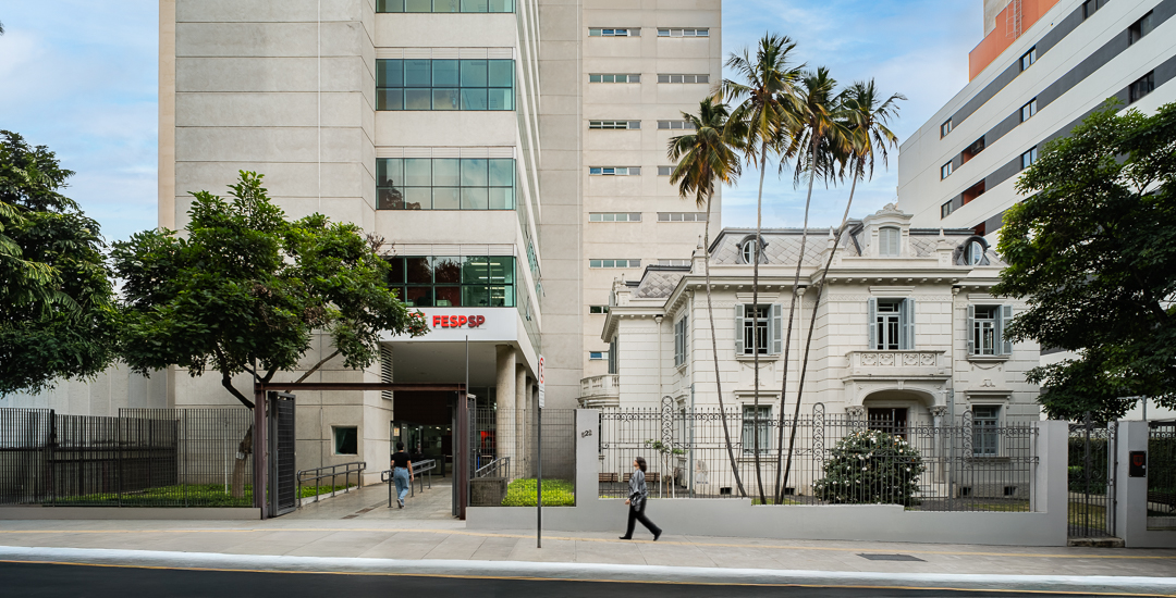 Vista da rua: casarão histórico e prédio moderno da FESPSP
